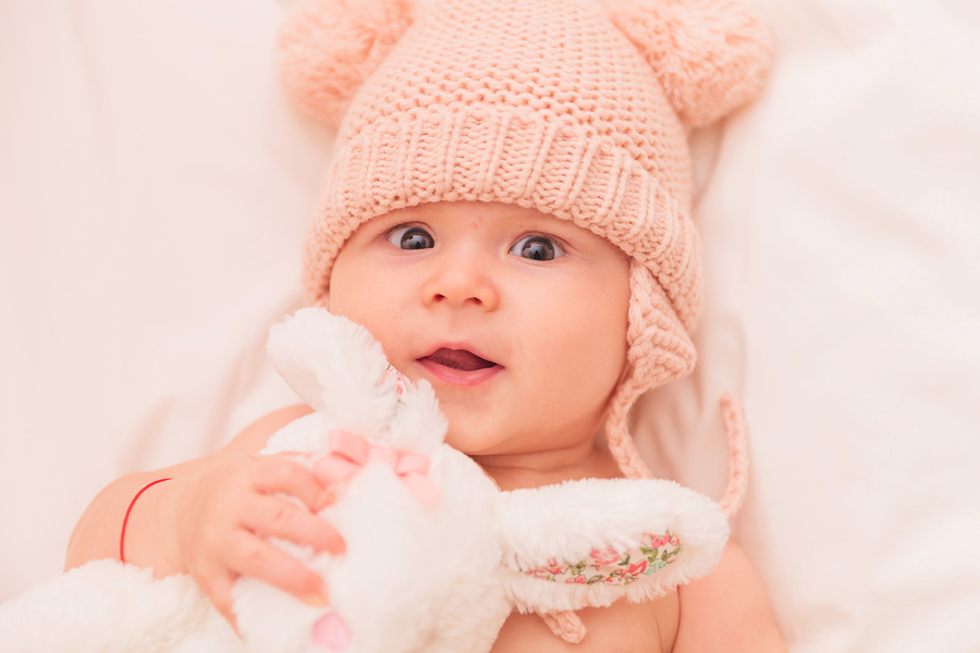close up picture of an adorable baby girl hugging her toy bunny