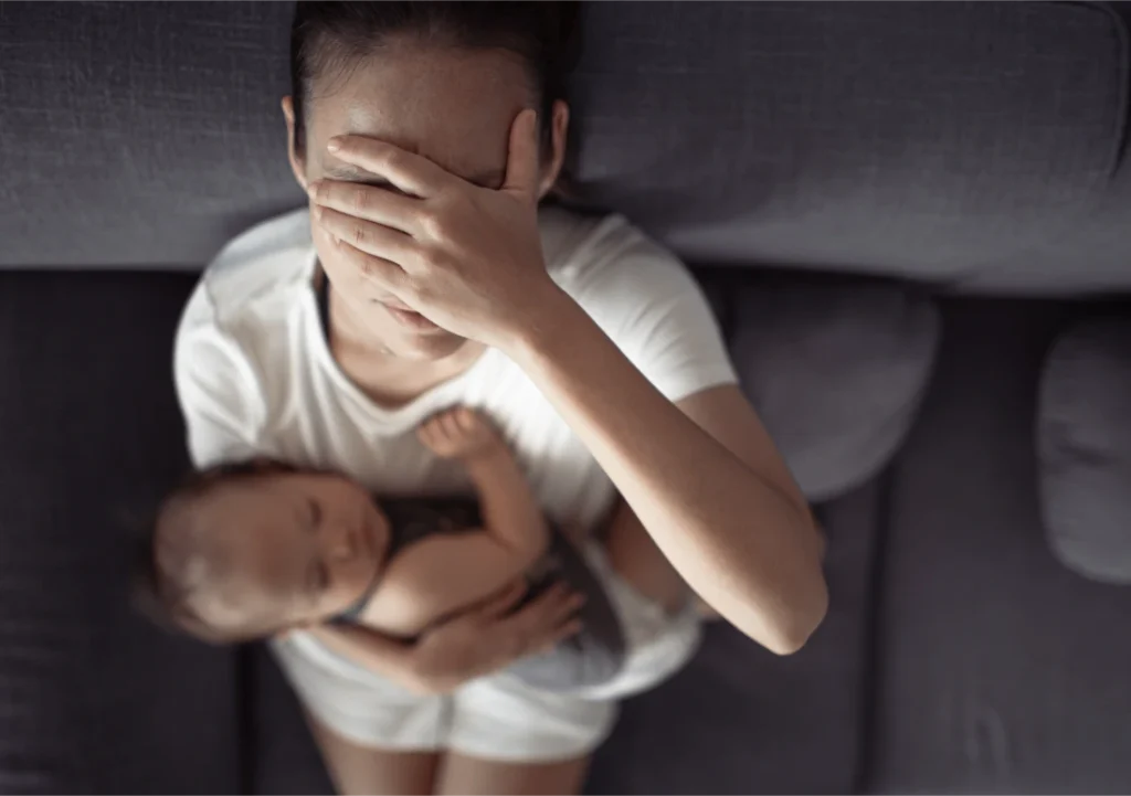 exhausted mother holding baby